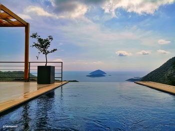 View of swimming pool by sea against sky