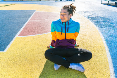 Portrait of young woman sitting on soccer field