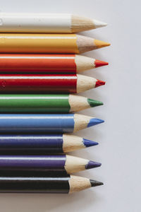 Rainbow of coloring pencils on plain white background