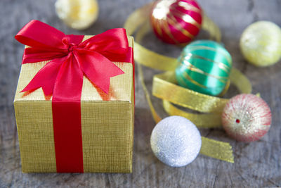 Close-up of gift box and baubles on table