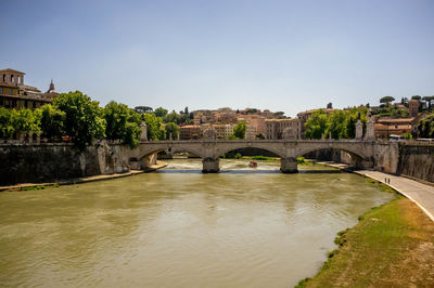 Arch bridge over river against sky