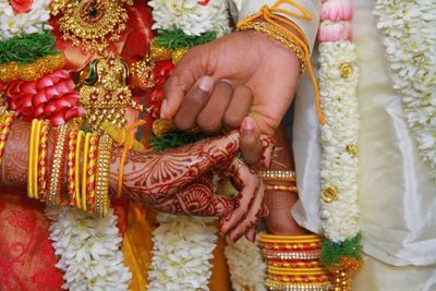 Midsection of couple holding hands