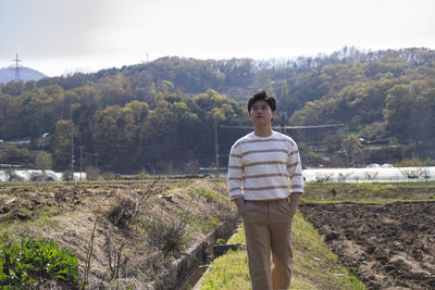 Portrait of a young man standing on landscape