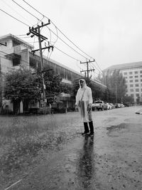 Rear view of man standing on wet street