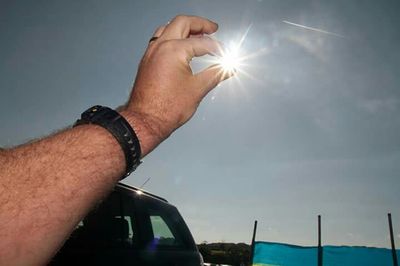 Low angle view of sun shining through clouds