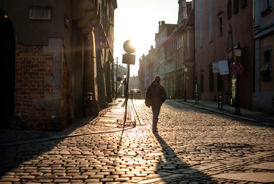 Rear view of man walking on street in city