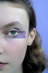 Teenage girl with make-up on face staring