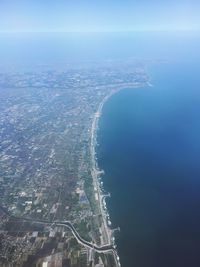 Aerial view of sea and cityscape against sky