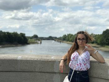 Portrait of woman standing against water