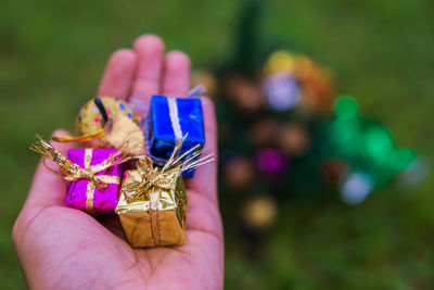 Close-up of hand holding gifts and decoration