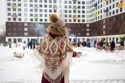 Rear view of woman standing on snow