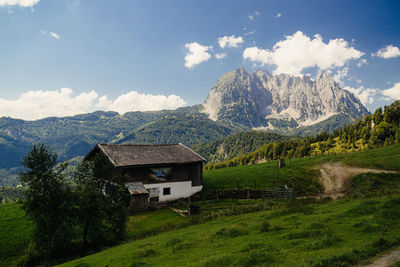 Scenic view of house and mountains against sky