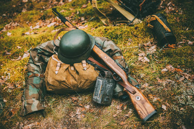 Military uniform and weapon on land in forest
