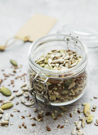 Mix different seeds for a healthy salad, glass jar on a gray concrete background