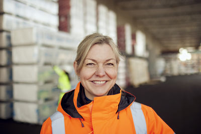 Portrait of smiling female worker in protective workwear at industry