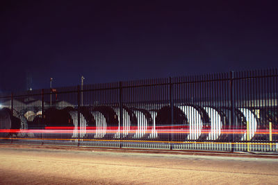 Train at railroad station against clear sky at night