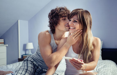 Young woman using phone while sitting at home