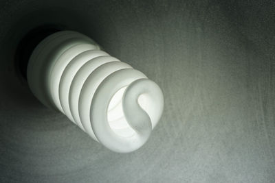 High angle view of spiral light bulb on table