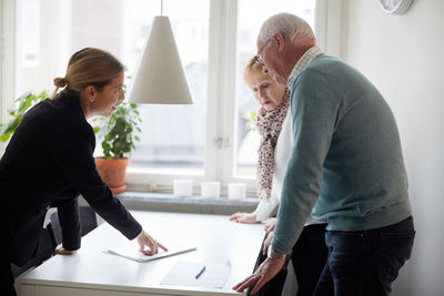 Realtor explaining documents of new house to senior couple