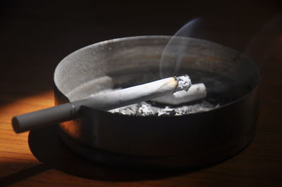 Close-up of cigarette smoking on table