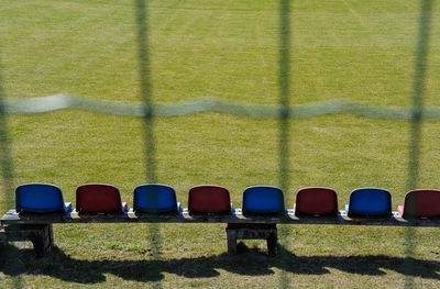 Row of chairs against plants on sunny day