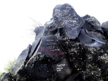 Low angle view of statue on rock against sky