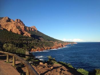 Scenic view of mountain by sea against sky