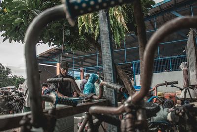 People standing on bicycle against trees