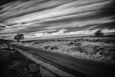 Empty road along countryside landscape