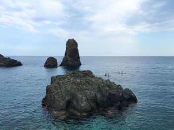 Rocks on sea shore against sky