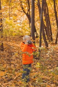 Rear view of man walking in forest during autumn