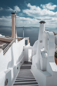 Steps leading towards sea against sky