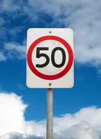 Low angle view of road sign against sky