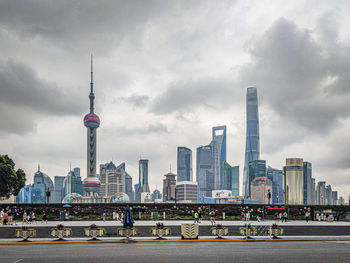 Modern buildings in city against cloudy sky