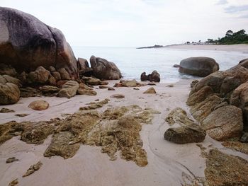 Rocks on beach against sky