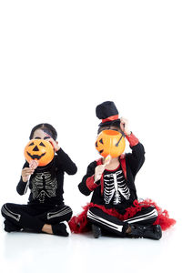 Children sitting on toy against white background