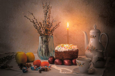 Various fruits in jar on table against wall