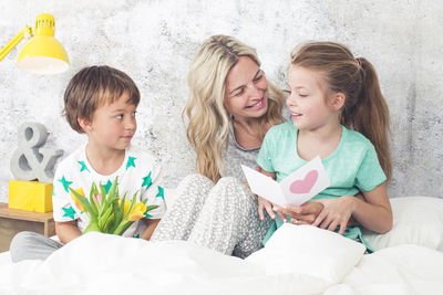 Happy family sitting on bed at home