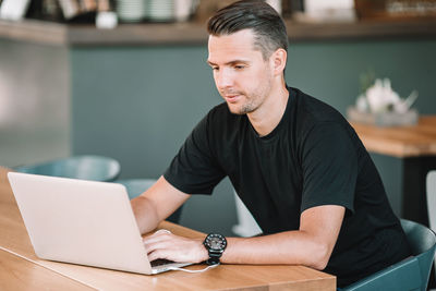 Man using laptop while sitting at cafe