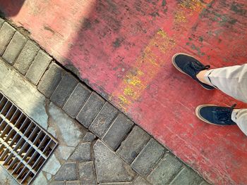 Low section of person standing on footpath