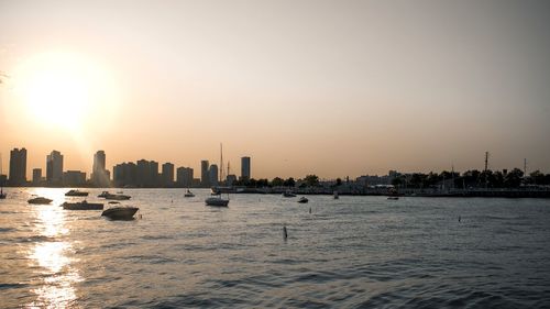 Scenic view of sea and buildings against sky during sunset