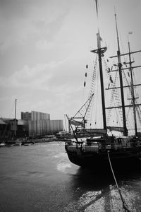 Ship moored at harbor against sky