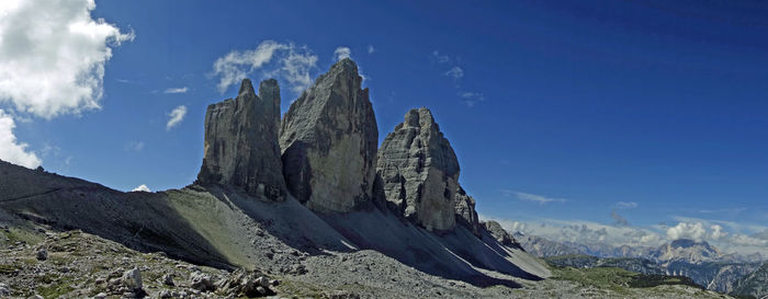 Panoramic view of rocky mountains against blue sky