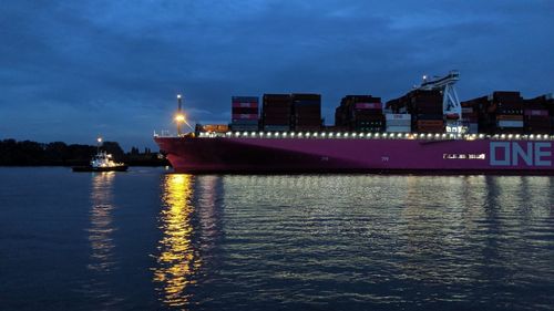 Illuminated ship in sea against sky at night