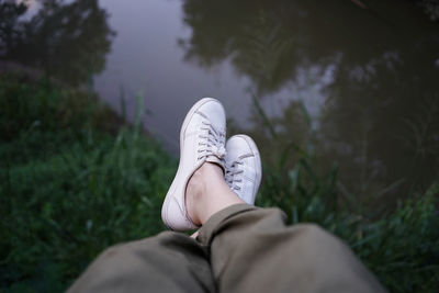 Low section of man relaxing over lake