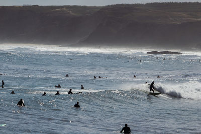 View of surfers on sea waiting for the perfect wave in baleal
