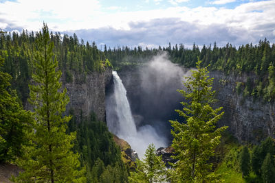 Scenic view of waterfall against sky