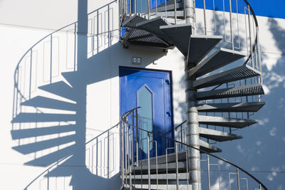 Low angle view of spiral stairs against blue sky