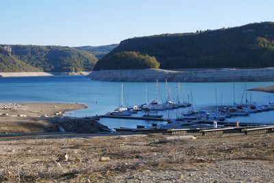 Sailboats moored in sea against clear sky