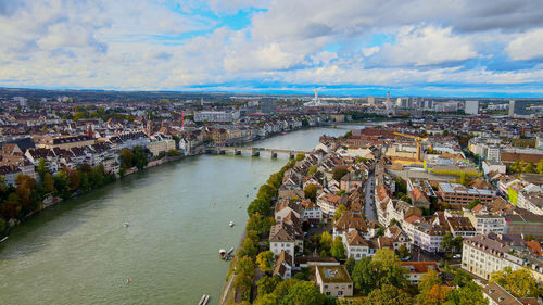 High angle view of townscape and river against cloudy sky